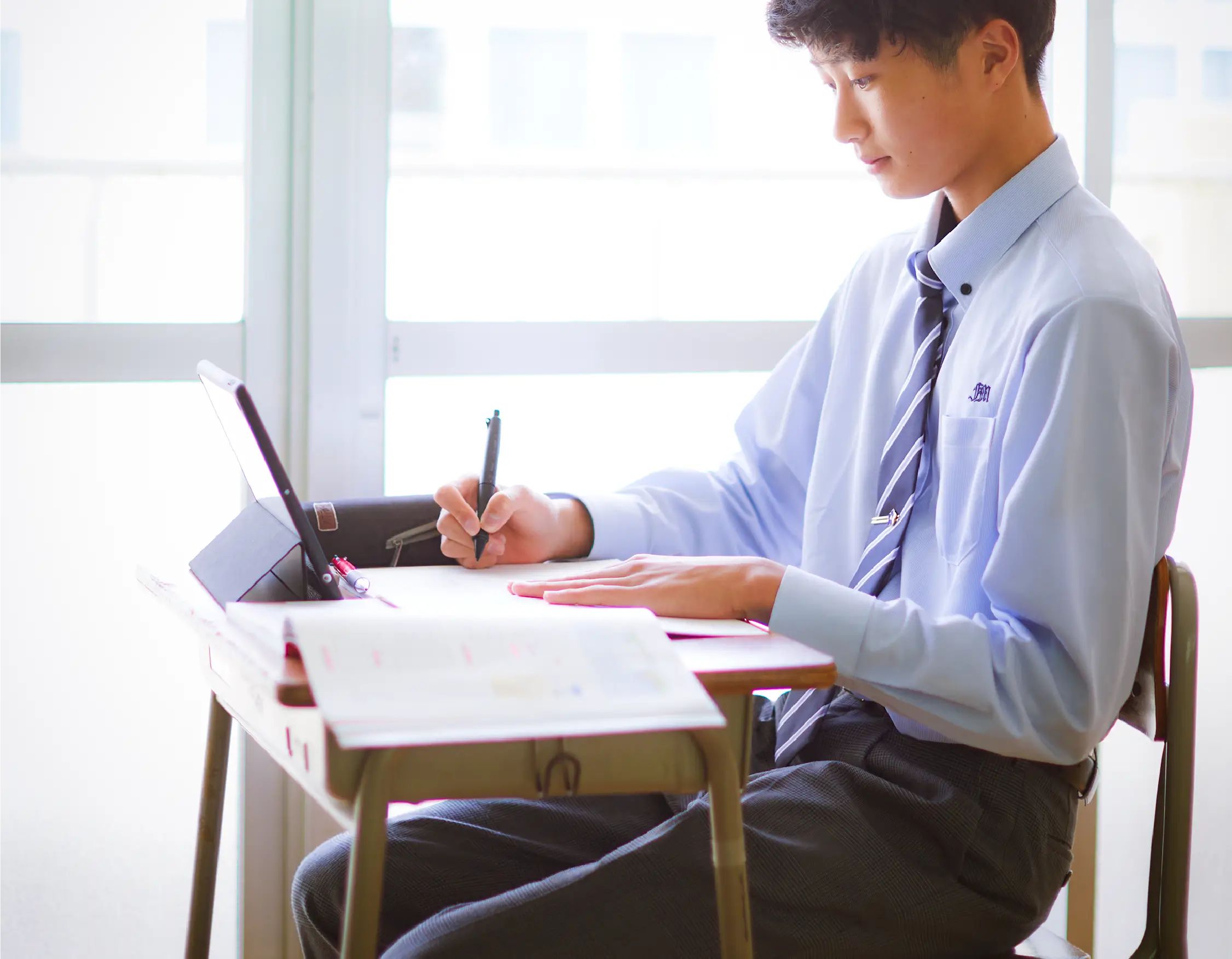 男子学生が机で勉強をしている様子