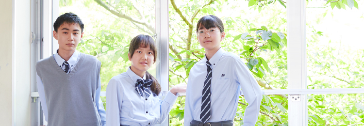 学生３人が窓の前で並んで写っている様子