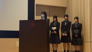 シンポジウム会場看板前での記念撮影